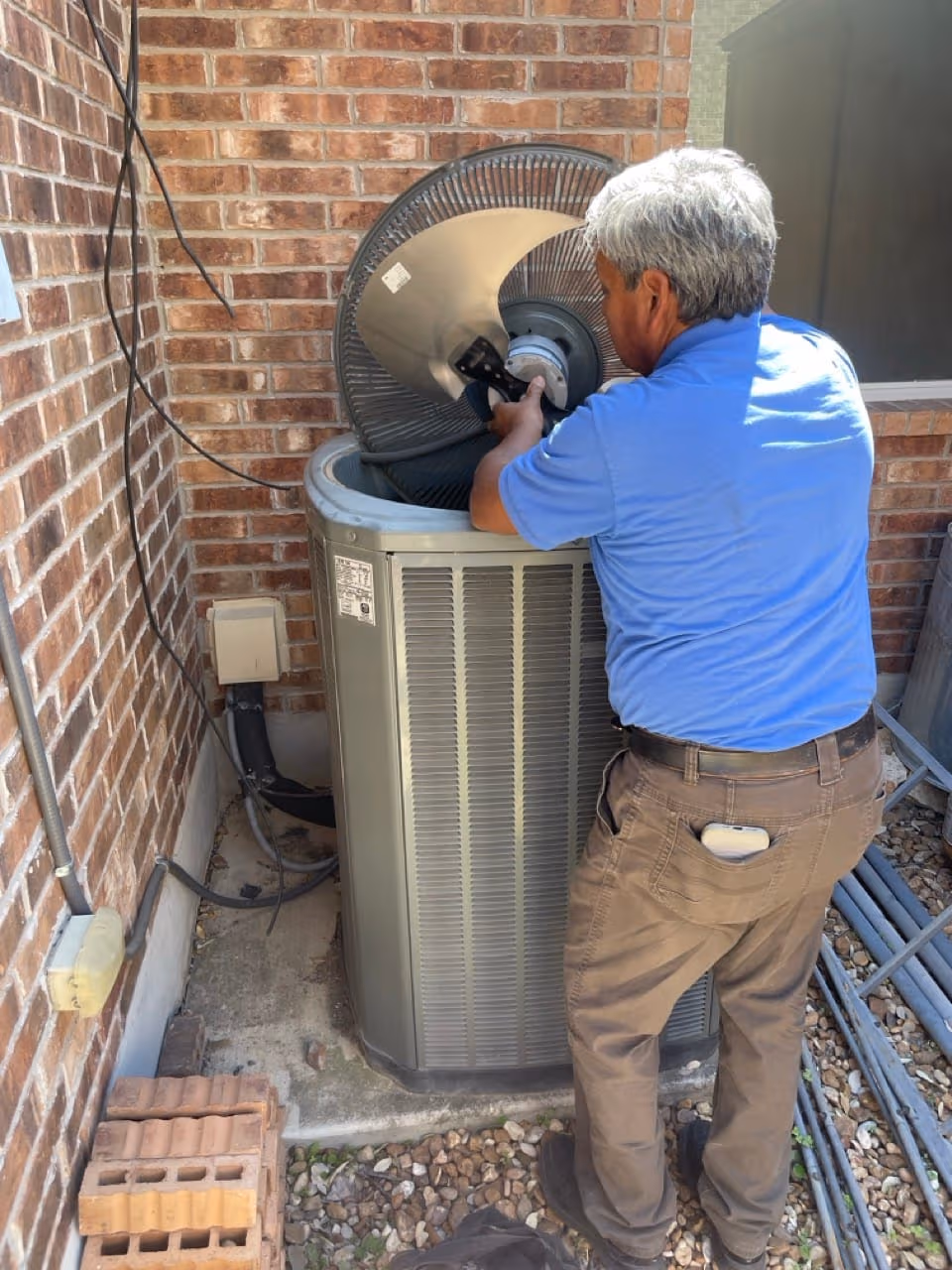 New outdoor AC condenser installed on a level concrete pad outside a San Antonio home